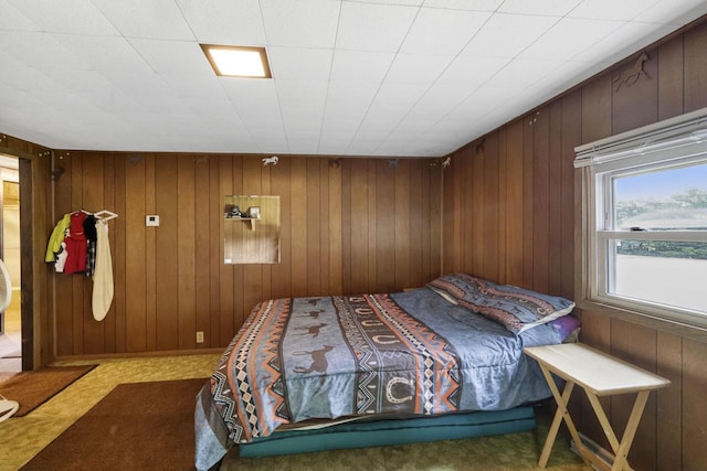 carpeted bedroom with wooden walls
