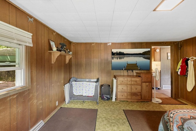 bedroom with carpet and wood walls