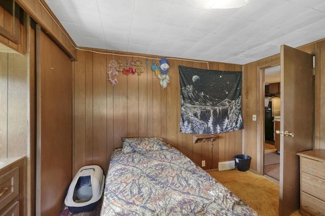 carpeted bedroom with wooden walls