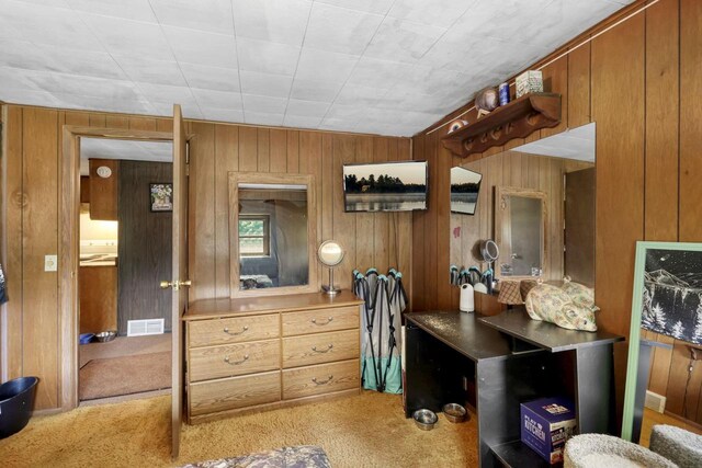 home office with wooden walls and carpet flooring