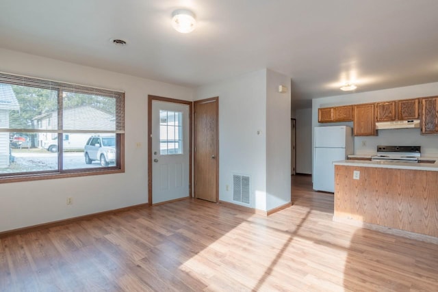 kitchen with range with electric cooktop, white fridge, and light hardwood / wood-style floors