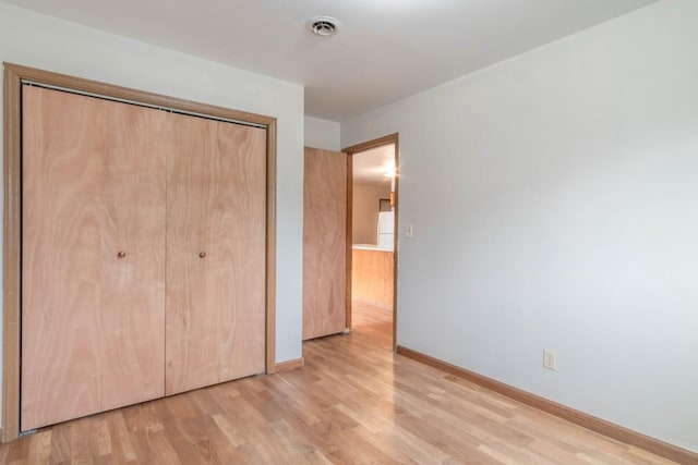 unfurnished bedroom featuring a closet and light hardwood / wood-style flooring