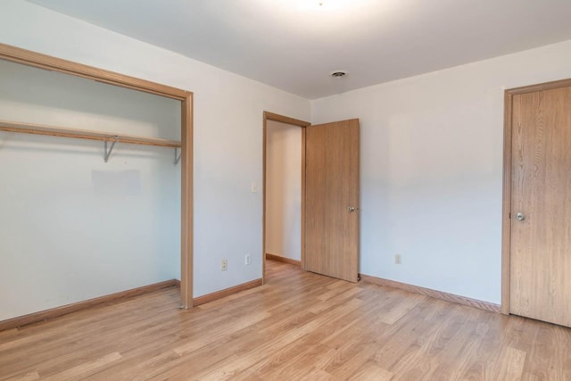 unfurnished bedroom featuring light hardwood / wood-style flooring and a closet