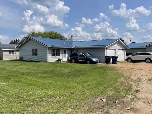 back of house with a garage and a lawn