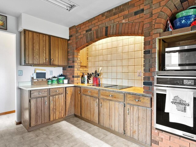 W7031 Hickory Ln, Elkhart Lake, WI 53020 - kitchen with wall oven, decorative backsplash, brown cabinets, light floors, and stainless steel microwave