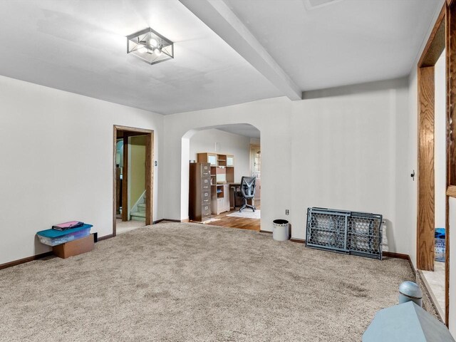 W7031 Hickory Ln, Elkhart Lake, WI 53020 - spare room with arched walkways, light carpet, beam ceiling, and baseboards