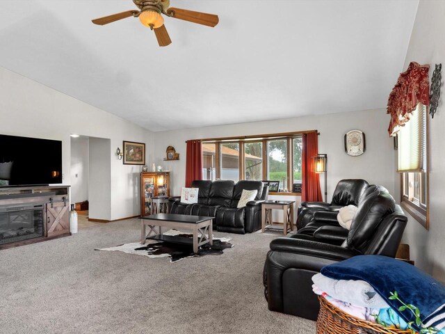 W7031 Hickory Ln, Elkhart Lake, WI 53020 - living room featuring lofted ceiling, a glass covered fireplace, a ceiling fan, and light colored carpet