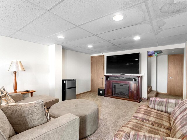 W7031 Hickory Ln, Elkhart Lake, WI 53020 - living area featuring light carpet, baseboards, a glass covered fireplace, stairway, and a paneled ceiling