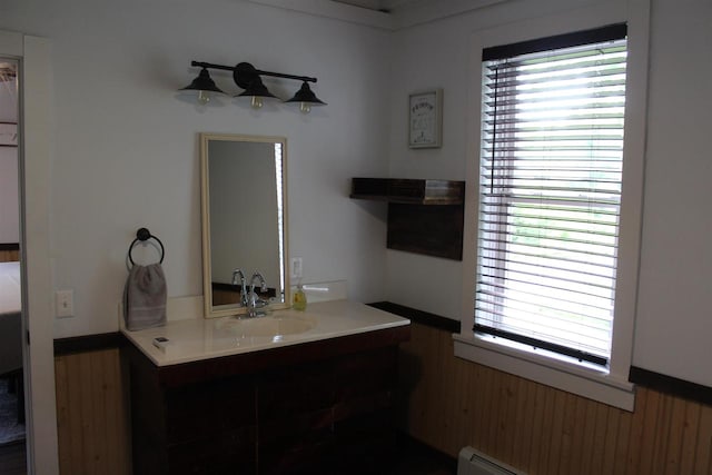 bathroom with wooden walls, baseboard heating, and vanity