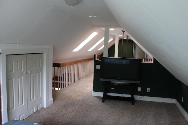 additional living space with lofted ceiling with skylight and carpet