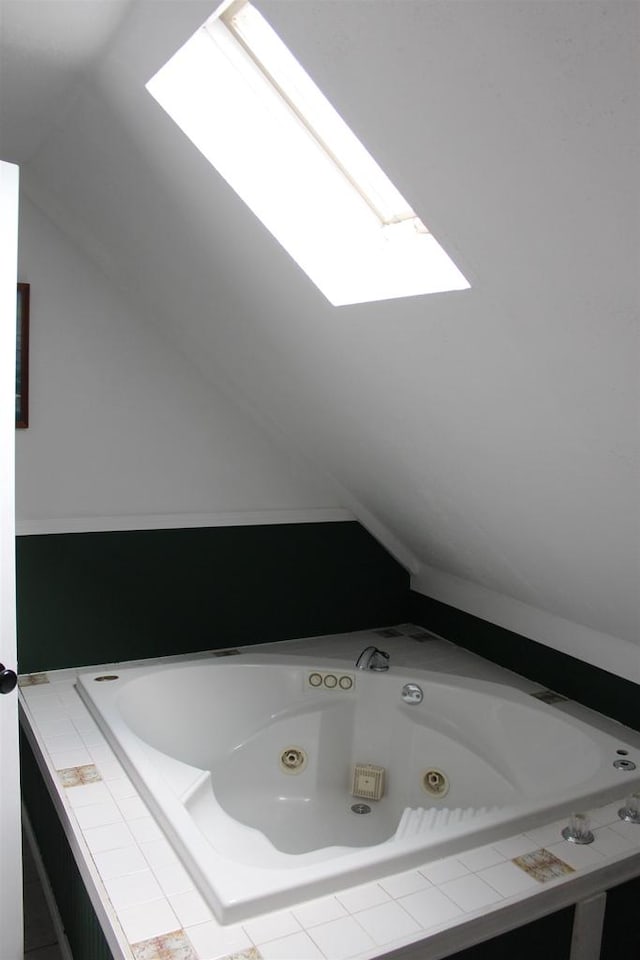 bathroom with tiled bath and vaulted ceiling