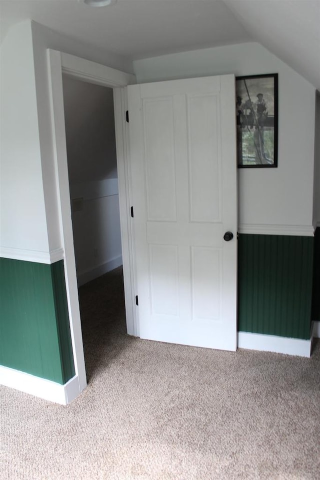 bonus room featuring vaulted ceiling and carpet