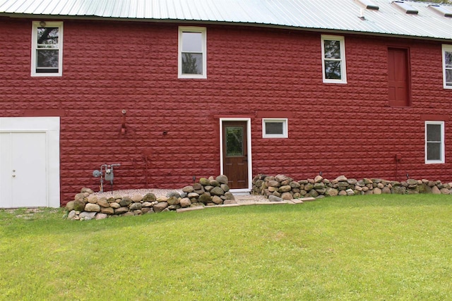 rear view of property featuring a lawn