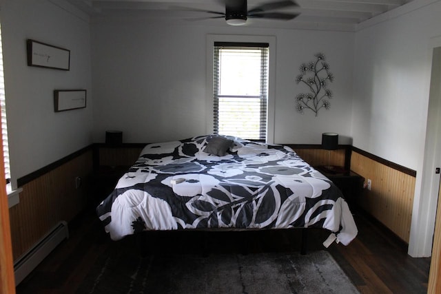 bedroom featuring dark wood-type flooring, wood walls, ceiling fan, and a baseboard radiator