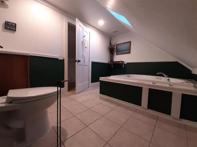 bathroom with lofted ceiling with skylight and tile patterned floors