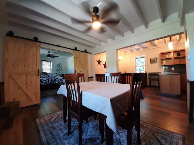 dining room with a barn door, dark hardwood / wood-style floors, and ceiling fan