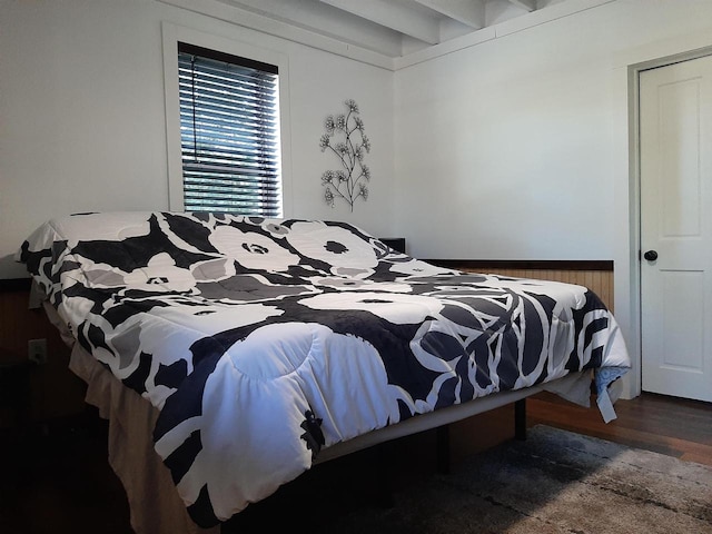 bedroom with beam ceiling and dark wood-type flooring