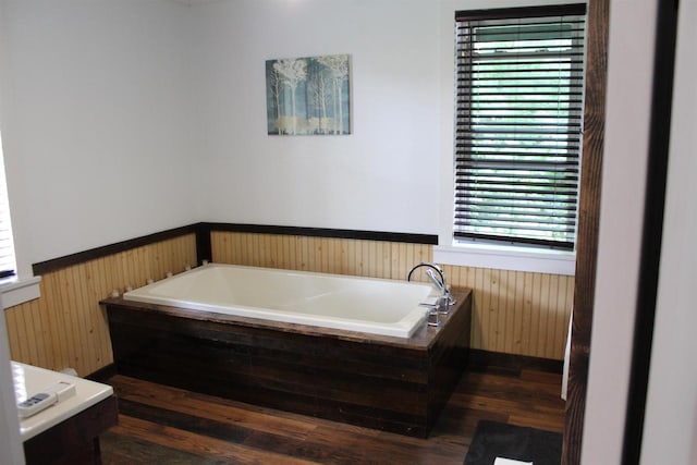 bathroom with a bath and wood-type flooring