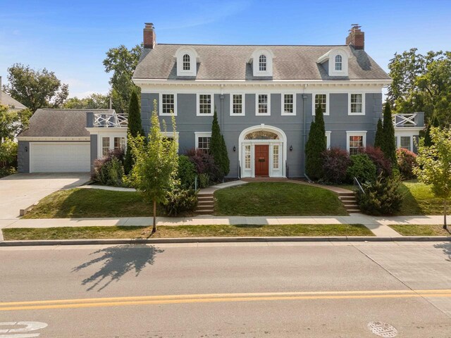 view of front of home featuring a balcony, a garage, and a front lawn