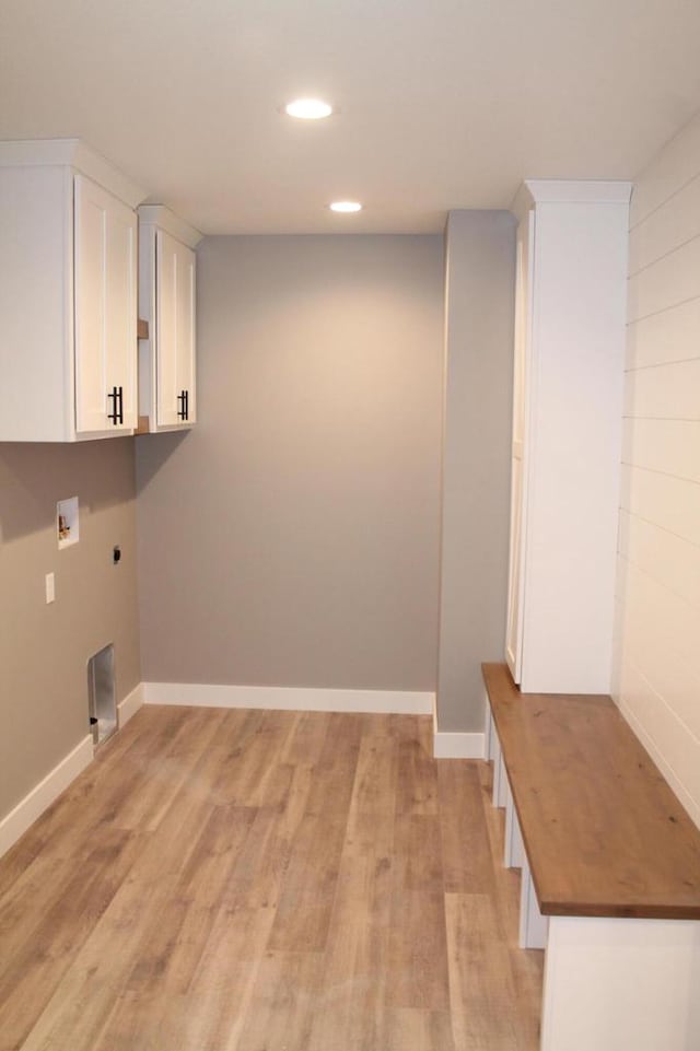 washroom featuring cabinets, hookup for a washing machine, light hardwood / wood-style floors, and hookup for an electric dryer