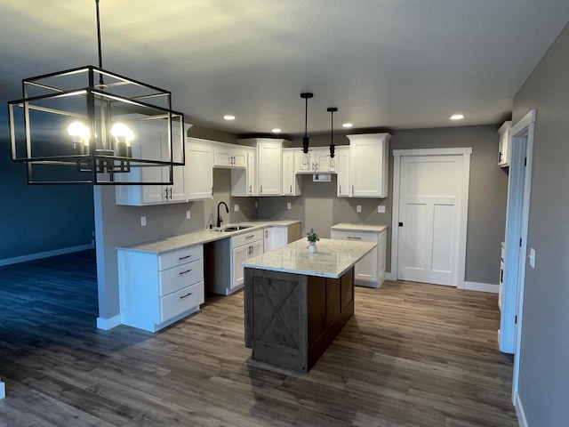 kitchen with pendant lighting, dark hardwood / wood-style flooring, sink, and white cabinets