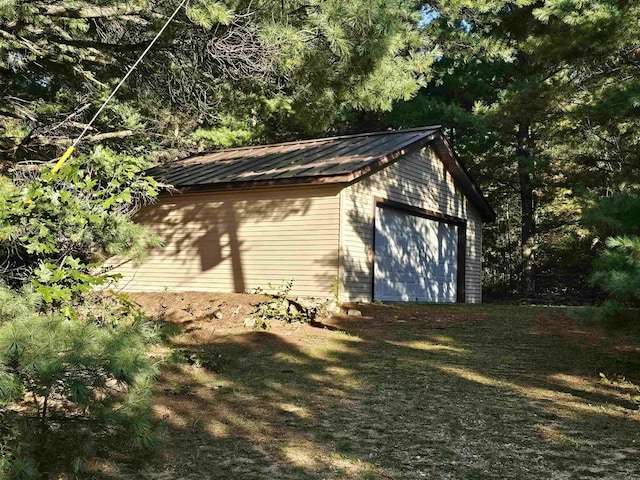 view of home's exterior with a garage and an outbuilding