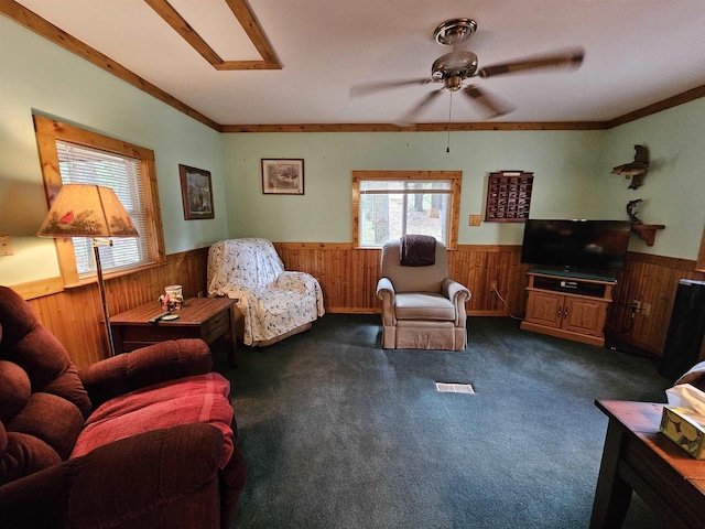 carpeted living room featuring ornamental molding and ceiling fan