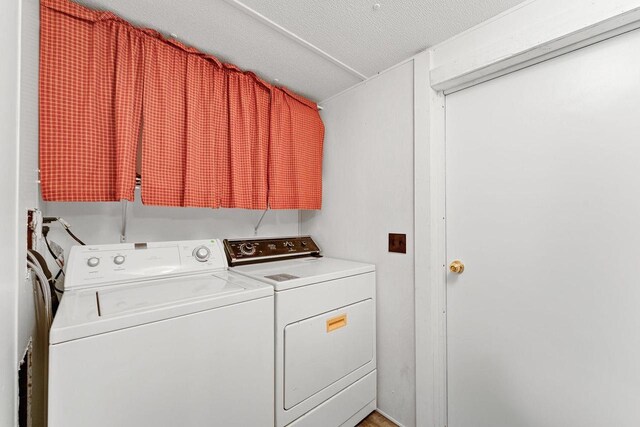 laundry room featuring separate washer and dryer and a textured ceiling