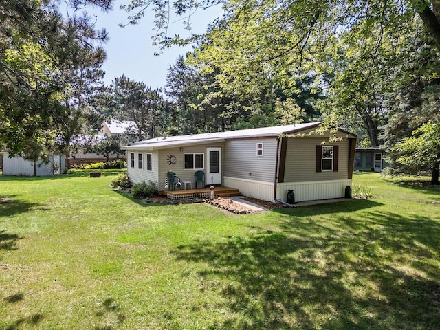 rear view of property featuring a lawn