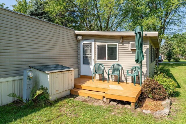 back of house with a wooden deck and a lawn