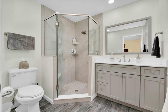 W12203 State Road 23, Ripon, WI 54971 - bathroom with vanity, toilet, a shower with door, and hardwood / wood-style floors