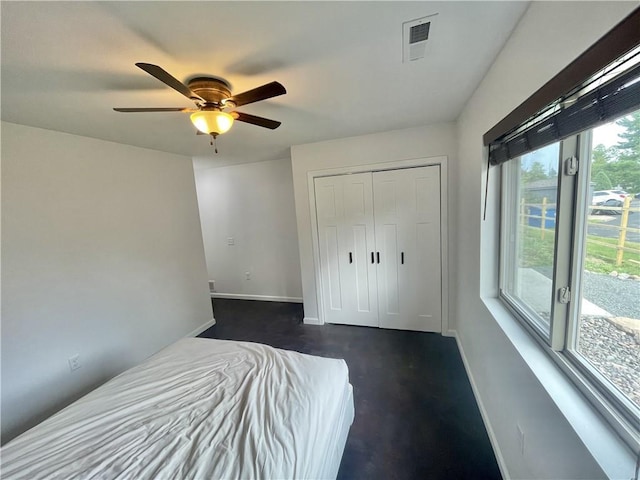 unfurnished bedroom with ceiling fan and a closet