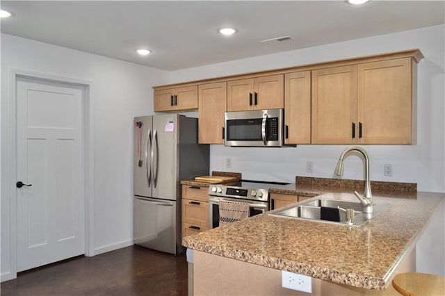 kitchen featuring appliances with stainless steel finishes, sink, a kitchen breakfast bar, light stone counters, and kitchen peninsula