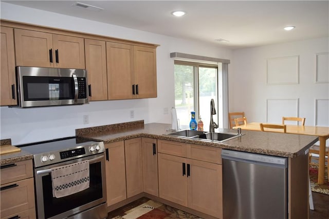 kitchen featuring sink, kitchen peninsula, and appliances with stainless steel finishes