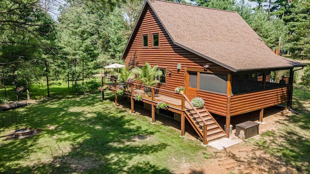 back of property featuring an outdoor fire pit, a yard, and a deck