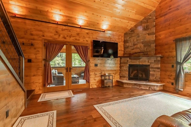 living room with hardwood / wood-style floors, wooden walls, a fireplace, lofted ceiling, and wooden ceiling