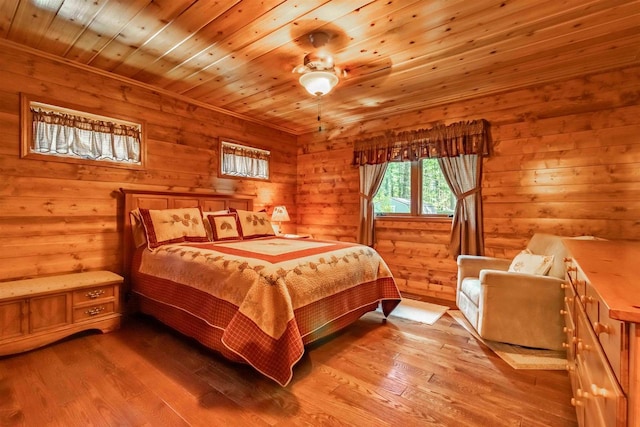 bedroom featuring wood ceiling, light hardwood / wood-style flooring, rustic walls, and ceiling fan