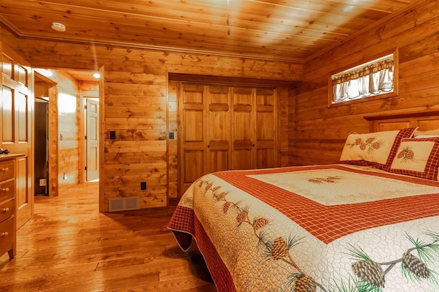 bedroom featuring hardwood / wood-style flooring, wood ceiling, and a closet