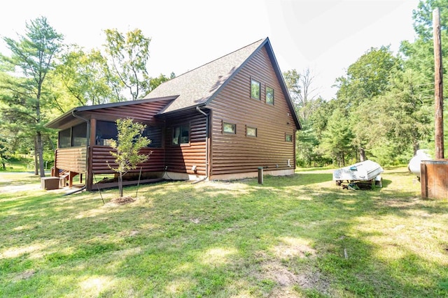 view of side of property featuring a sunroom and a lawn