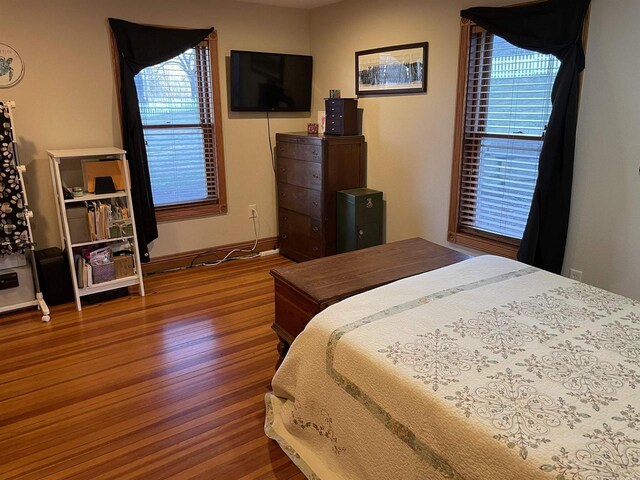 bedroom with hardwood / wood-style flooring and multiple windows