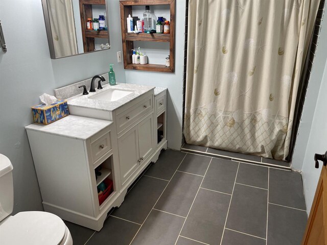 bathroom featuring tile patterned floors, vanity, and toilet