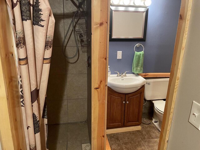 bathroom featuring tile patterned flooring, toilet, and vanity