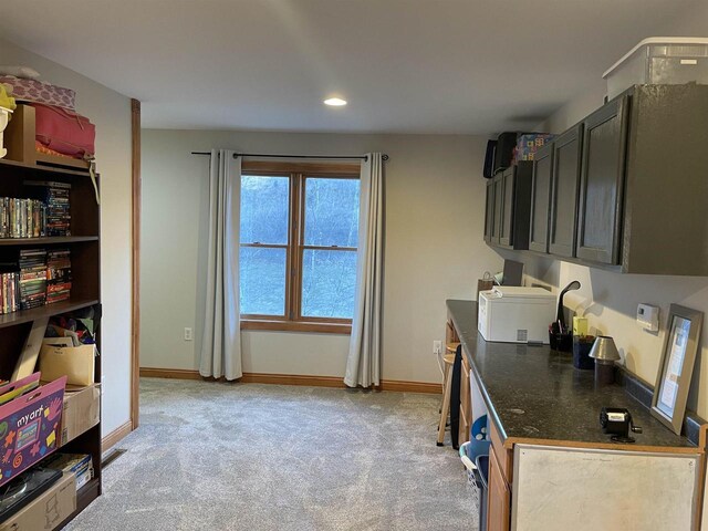 kitchen with light colored carpet and dark stone counters