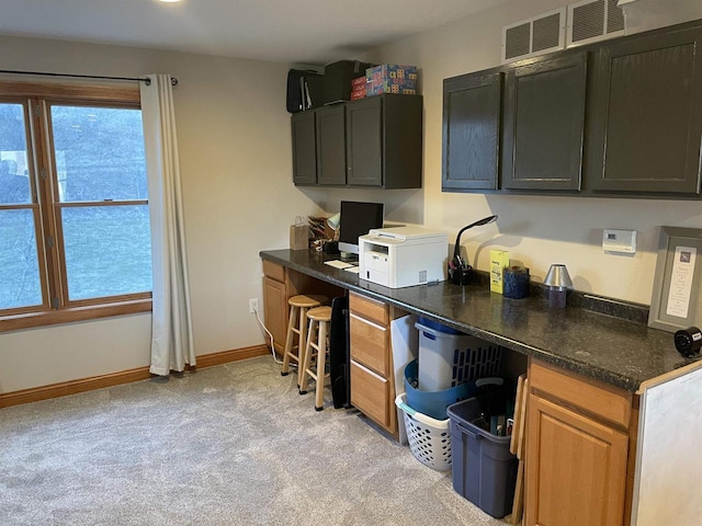 kitchen with built in desk and light carpet