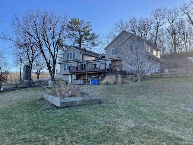 rear view of property featuring a lawn and a deck