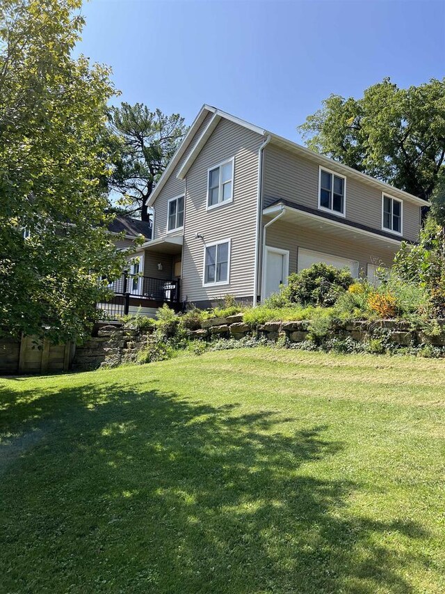 rear view of house with a wooden deck and a lawn