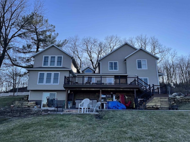 rear view of property with a yard and a wooden deck