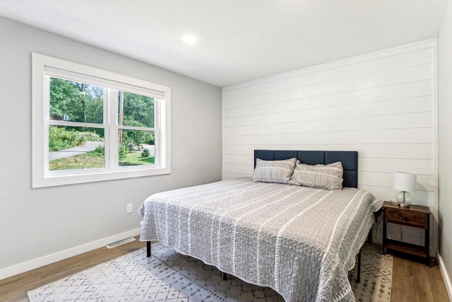 bedroom featuring visible vents, baseboards, and wood finished floors
