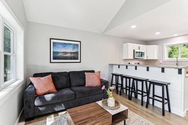 living room featuring light wood-style flooring, recessed lighting, and baseboards