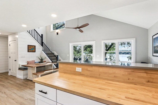 kitchen with ceiling fan, vaulted ceiling, white cabinets, recessed lighting, and light wood finished floors